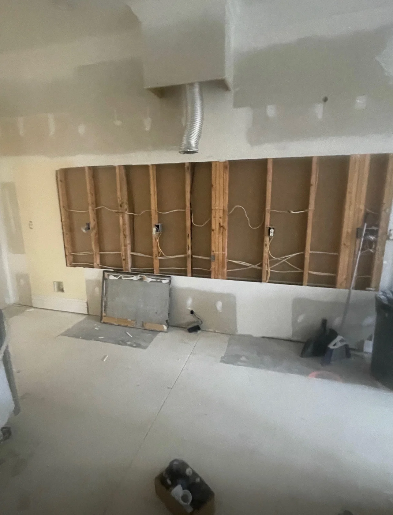Kitchen before remodel with original cabinet and fridge wall